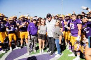 Coach Burleson posing with his family 和 players